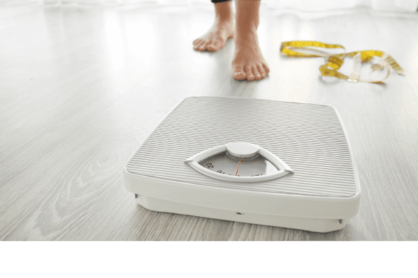 Balança com pés femininos e elementos decorativos